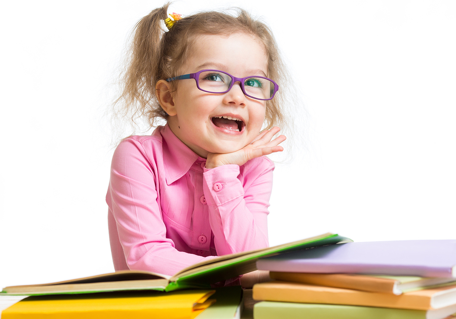 Funny kid girl in glasses reading books