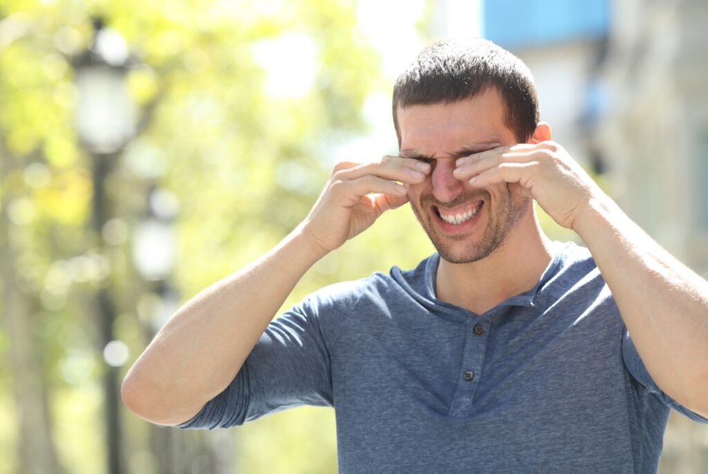 Man rubbing his eyes Spring allergies.
