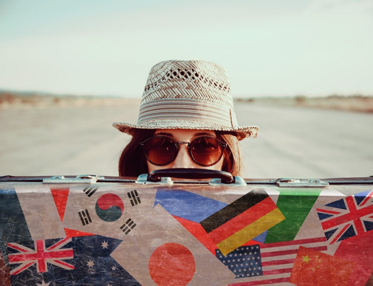 Woman with hat, sunglasses, and suitcase for travel