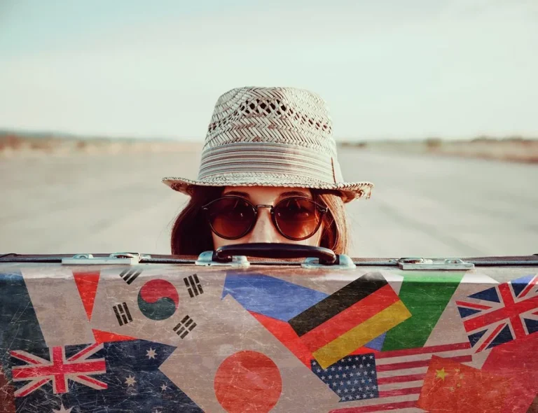 Woman with hat, sunglasses, and suitcase for travel